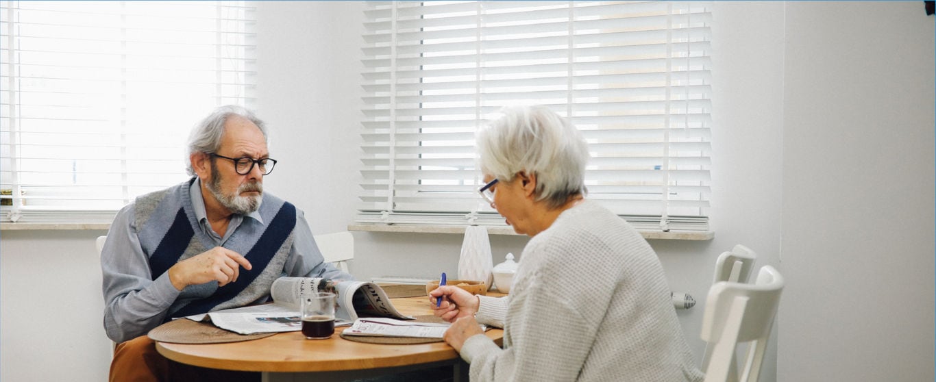 Couple sitting at table looking over paper work