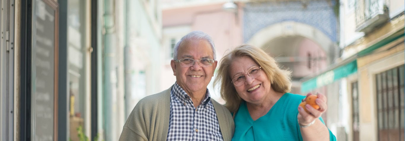 Elderly Couple One holding oranges