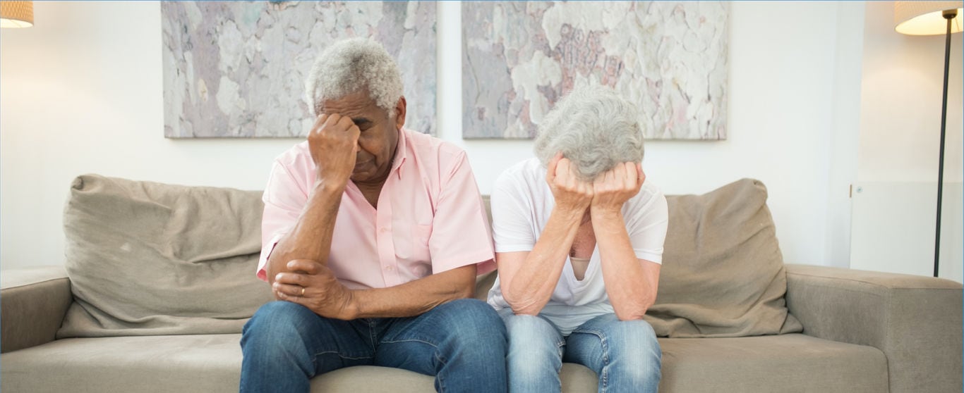 Older couple with there hands on their face